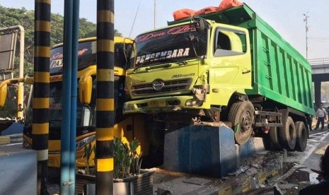 Sebuah dump truk menabrak bus di depan gerbang Tol Sidoarjo.