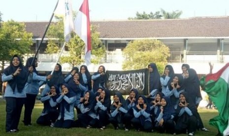 Puluhan siswa SMKN 2 Sragen berpose sambil mengibarkan bendera berwarna hitam bertuliskan kalimat tauhid.