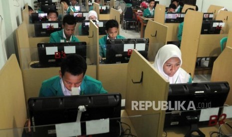 Sejumlah pelajar saat akan memulai Ujian Nasional Berbasis Komputer (UNBK) di Madrasah Tsanawiyah (MTs) Fatahillah, Jakarta, Senin (23/4).