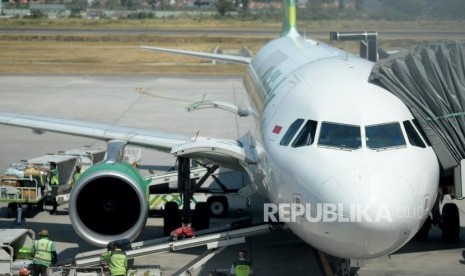 Petugas menurunkan bagasi milik penumpang pesawat di Bandara Internasional Ahmad Yani,Semarang,Jawa Tengah,Rabu (10/7).