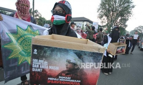 Ratusan massa dari sejumlah elemen organisasi menggelar aksi Save Ghouta, di depan Gedung Sate, Bandung, Jumat (2/3).