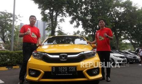 Marketing and After Sales Director PT Honda Prospest Motor Jonfis Fandy (kiri) bersama Businesss and Product Planning Director PT Honda Prospect Motor Takayuki Uotani (kanan) berfoto bersama di mobil All New Honda Brio seusai serah terima mobil kepada konsumen di Jakarta, Sabtu (13/10).