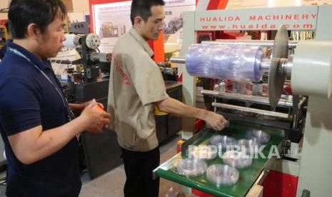 Seorang operator mesin, sedang mengoperasikan mesin pencetak plastik yang sedang beroperasi  pada pameran Indoplas, Indopack, Indoprint di JIEXPO Kemayoran Jakarta, Rabu (19/9).