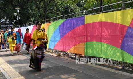 Pengunjung melintas mengunakan pakaian adat di kompleks Gelora Bung Karno Jakarta, Sabtu (18/8).