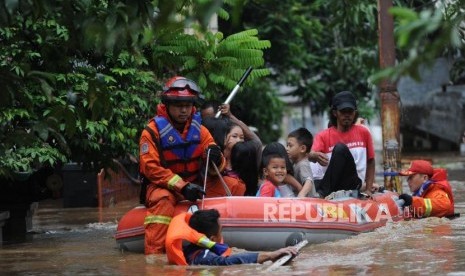 Petugas pemadam kebakaran mengevakuasi warga yang terjebak banjir di kawasan Pejaten Timur,Jakarta, Senin (5/2).