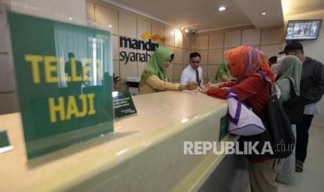 Petugas layanan nasabah melayani calon jamaah haji yang akan melakukan pelunasan Biaya Penyelenggaraan Ibadah Haji (BPIH) di Kantor Cabang Mandiri Syariah Area Bekasi, Jawa Barat, Selasa (19/3/2019). Sudah 96,65 Persen Jamaah Reguler Lunasi Biaya Haji