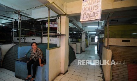 Pedagang berdiam diri disamping kios-kios yang tutup di Blok G Pasar Tanah Abang, Jakarta Pusat, Jumat (17/11).