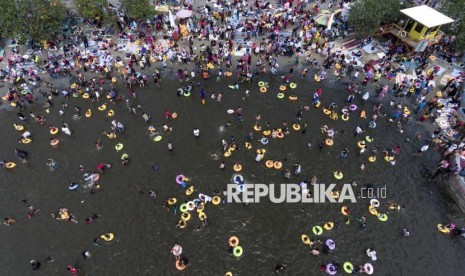 Foto aerial suasana pengunjung bermain di pantai Ancol, Jakarta, Senin (26/6). PT Pembangunan Jaya Ancol selaku pengelola memprediksi pada hari kedua Lebaran pengunjung mencapai 100 ribu orang dan ditargetkan dapat mencapai 875 ribu orang selama delapan hari libur Lebaran tahun ini. ANTARA FOTO/Sigid Kurniawan/foc/17.