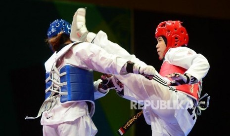 Atlet Taekwondo Putri Indonesia Shaleha Fitriana Yusuf (merah) melancarkan tendangan ke arah lawannya dari Philipina Darlene Mae Arpon (biri) pada babak final kelas under 67 kg pada ajang  Invitation Tournament Asian Games 18 di Jakarta, Ahad (11/2).