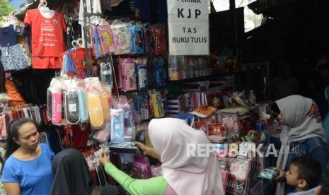 Sejumlah calon pembeli saat mencari perlengkapan sekolah untuk anaknya di Pasar Jatinegara, Jakarta, Ahad (14/7).