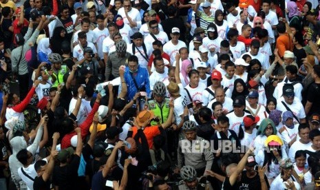 Peserta Aksi 2019 Ganti Presiden bertemu denga peserta jalan santai dia sibuk kerja di hari bebas kendaraan bermotor di Kawasan Bundaran Hotel Indonesia, Jakarta, Ahad (29/4).