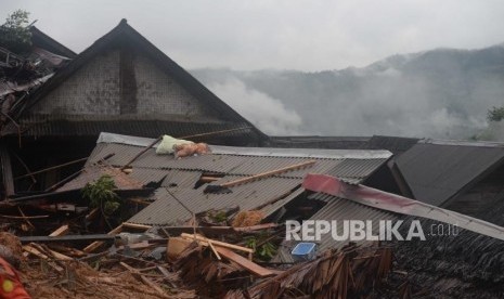 Longsoran rumah menutupi rumah penduduk di dusun Cimapag, Desa Sinaresmi, Cisolok, Sukabumi, Jawa Barat, Selasa (1/1).