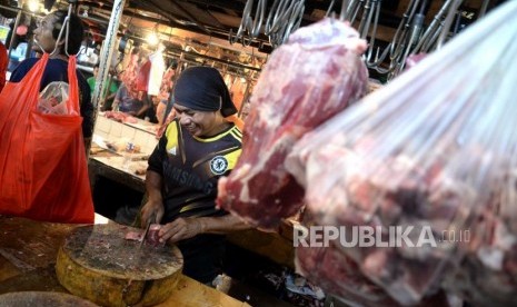 HET Daging Sapi Tidak Efektif. Pedagang memotong daging sapi di Pasar Senen, Jakarta, Jumat (26/1).