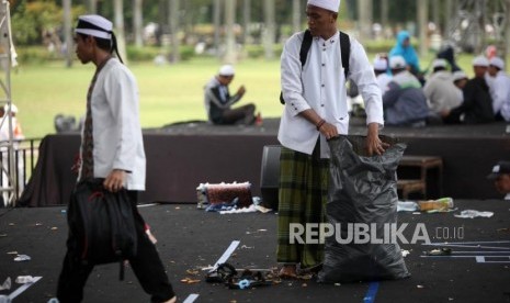 Peserta reuni aksi 212 mengumpulkan sampah seusai Reuni Aksi 212 di Lapangan Monumen Nasional, Jakarta, Ahad, (2/12).