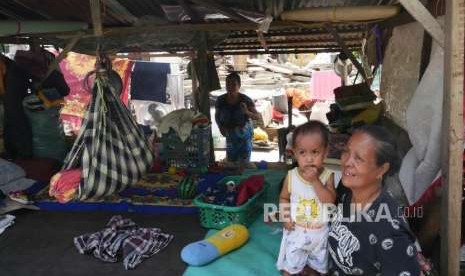 Seorang ibu, bersama cucuknya terpaksa harus tinggal di tenda pengungsi di depan rumahnya di Desa Salua, Kecamatan Sigi, Sulawesi tengah, kamis (10/10).