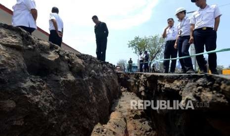 Petugas melihat kondisi area parkir ruang tunggu yang retak akibat gempa di Pelabuhan Kayangan, Lombok Timur, NTB, Selasa (21/8).