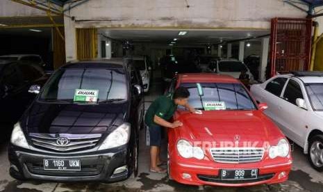 Pegawai membersihkan mobil bekas yang dijual di bursa mobil Geraldi Auto, Pondok Bambu, Jakarta, Kamis (11/10).