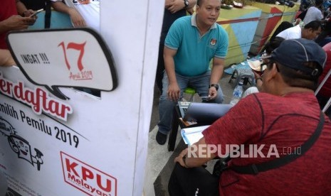 Petugas KPUD DKI Jakarta membantu penegcekan DPT warga saat Hari Bebas Kendaraan Bermotor di Kawasan Bundaran HI, Jakarta, Ahad (21/10).