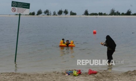 Pengunjung bersama anak-anaknya berenang di pinggiran pantai Taman Impian Jaya Ancol Jakarta (ilustrasi)