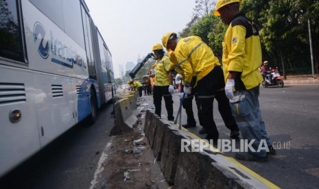 Petugas Bina Marga merapikan pembatas jalur transjakarta pasca aksi 24 September 2019 di Gedung DPR/MPR Senayan, Jalan Gatot Soebroto, Jakarta, Rabu (25/9/2019).