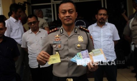 Kapolsek Metro Tanah Abang AKBP Lukman Cahyono memperlihatkan barang bukti karsis dan uang saat rilis kasus retribusi dan parkir liar di Polsek Metro Tanah Abang, Jakarta, Senin (4/6).