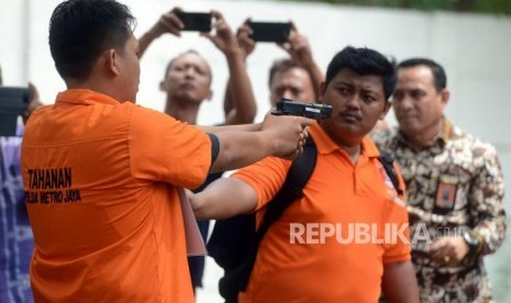 Sejumlah petugas kepolisian bersama tersangka saat reka ulang adegan kasus peluru nyasar di Lapangan Tembak, Senayan, Jakarta Selatan, Jumat (19/10).