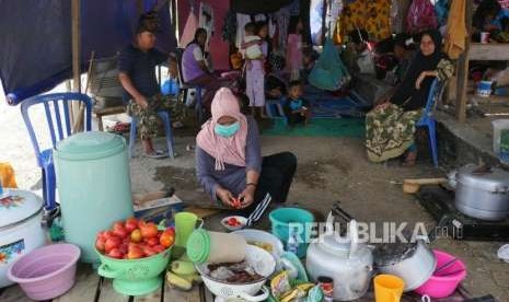 Seorang ibu mempersiapkan bahan makanan untuk dimasak di dapur umum darurat untuk keluarganya di tempat pengungsian Duyu, Palu Barat, kecamatan Tatanga, Selasa (9/10).