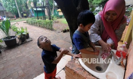 Salah seorang guru mengajarkan mencuci tangan kepada murid di Sekolah Citra Alam, Jagakarsa, Jakarta, Senin (18/12).