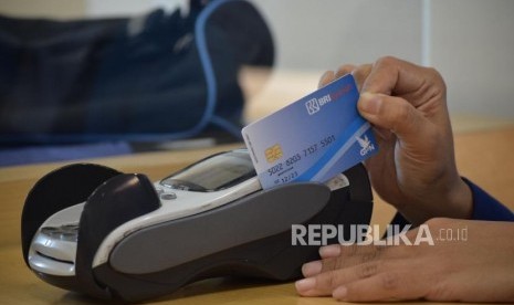 Petugas melayani transaksi nasabah di kantor layanan BRI Syariah, Jakarta, Rabu (24/10).