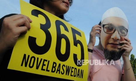 Activists hold posters to urge the government to solve the case of attack against Novel Baswedan in a rally to commemorate 1 year of the attack, in front of Merdeka Palace, Jakarta, Wednesday (April 11).