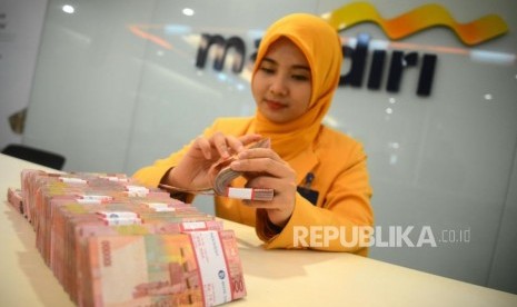 Teller menghitung mata uang rupiah di Bank Mandiri, ilustrasi. Bank Mandiri berencana menerbitkan surat utang berdenominasi rupiah.