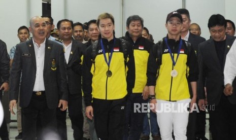 Pebulu tangkis ganda putra Indonesia Kevin Sanjaya Sukamuljo  dan Marcus Fernaldi Gideon (tengah) tiba di Bandara Internasional Soekarno Hatta, Tangerang, Banten, Selasa (20/3).