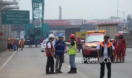 Petugas  mengevakuasi crane yang roboh di KM 15 Tol Jakarta-Cikampek di Wilayah Kota Bekasi, Jawa Barat, Kamis (16/11).