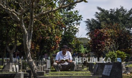 Peziarah berdoa di makam keluarganya saat ziarah kubur di TPU Sirnaraga, Jalan Pajajaran, Kota Bandung, Jumat (3/5).