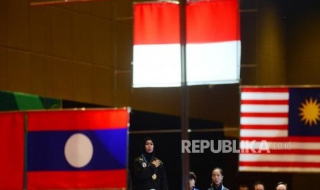 Atlet putri Taekwondo Indonesia Defia Rosmaniar memberikan hormat kepada bendera Merah Putih usai pengalungan Medali Emas usai memenangkan babak final perorangan Poomsae di event Invitation Torunament Asian Games 18 di Jakarta, Sabtu (10/2).