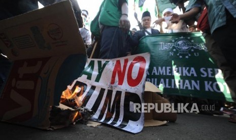 Pembakaran. Peserta aksi melakukan pembakaran bendera poster  bertuliskan say no trump dalam  aksi damai di depan kantor Kedutaan Amerika Sertikat, Jakarta, Jumat (08/12).