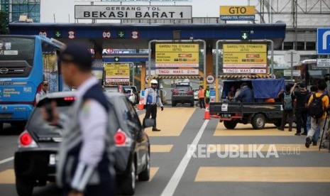 Kendaraan mobil dengan nomor polisi ganjil memutar balik saat hari pertama pemberlakuan sistem ganjil genap di Gerbang Tol Bekasi Barat 1, Bekasi, Jawa Barat, Senin (12/3).