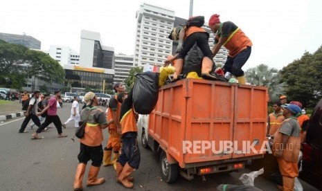 Petugas PPSU membersihkan sampah pasca aksi reuni 212 di kawasan Tugu Tani, Jakarta, Ahad (2/12).