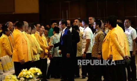 Perayaan HUT Golkar. Presiden Joko Widodo menyalami Ketua Dewan Pakar Partai Golkar saat memasuki ruangan Perayaan HUT Golkar ke-54 di JiExpo, Jakarta, Ahad (21/10).