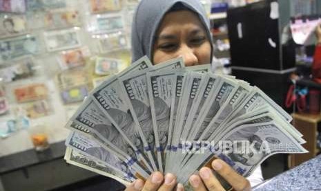 Menukarkan Dolar AS. Petugas menghitung mata uang Dolar As warga saat menukarkan mata uang di jasa penukaran mata uang, Jakarta, Rabu (5/9).