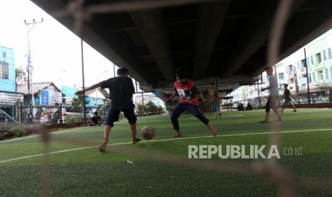 Sejumlah anak-anak bermain bola di Taman Baca Kolong Jembatan Layang Ciputat, Tangerang Selatan, Banten, Selasa (5/12).