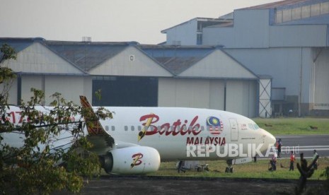 Petugas memeriksa pesawat Batik Air Malaysia yang gagal lepas landas karena keluar landasan pacu, di Bandara Husein Sastranegara, Kota Bandung, Kamis (20/6).