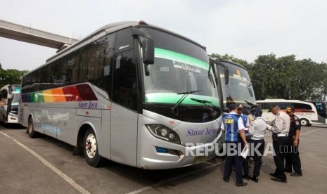 Petugas mengecek surat kendaraan bus dalam massa Pra Angkutan Lebaran 2018 di Terminal Kampung Rambutan, Jakarta, Senin (28/5).