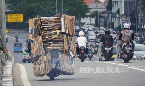 Sebuah sepeda motor dengan bermuatan tumpukan kardus bekas melintas di kisaran fly over Senen Jakarta, Selasa (4/7). Membawa barang dengan kapasitas berlebih pada sepeda motor dapat membahayakan dipengendara dan pengguna jalan lainnya. Foto: darmawan.