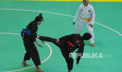 Pesilat putri Indonesa Nirmalasari Oktaviani  (kanan) sedang melepaskan tendangan  pesilat Laos Olathai   Sounthavong(kiri) saat pertandingan babak semifinal kelas 50-55 kg putri pencak silat 18th Asian Games Invitation Tournament di Padepokan Pencak Silat TMII, Jakarta, Senin (12/2).