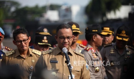 Gubernur DKI Jakarta Anies Baswedan (tengah) bersama Wakil Gubernur DKI Jakarta Sandiaga Salahudin Uno (kiri) dan Kapolda Metro Jaya Inspektur Jenderal Polisi Idham Azis (kanan) memberikan keterangan kepada media seusai apel Mantap Praja Jaya 2017 di Polda Metro Jaya, Jakarta, Selasa (31/10).