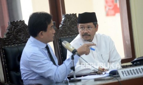 Kuasa Hukum HTI Yusril Ihza Mahendra berbincang dengan mantan juru bicara HTI Ismail Yusanto dalam sidang perdana gugatan HTI terhadap langkah pemerintah yang mencabut status badan hukumnya di PTUN Jakarta, Kamis (23/11).