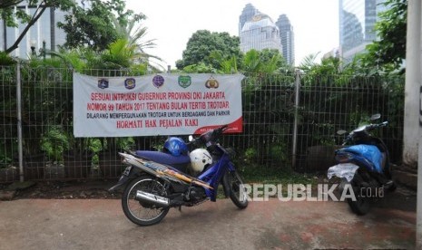 Kendaraan bermotor  melakukan parkir liar di  trotoar kawasan Jalan Sudirman, Jakarta Pusat, Ahad (17/12).