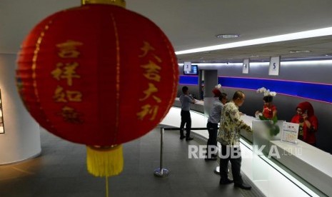 Nasabah melakukan transaksi saat festival Li Chun, satu hari sebelum perayaan imlek di Bank UOB Indonesia, Jakarta, Senin (4/2).