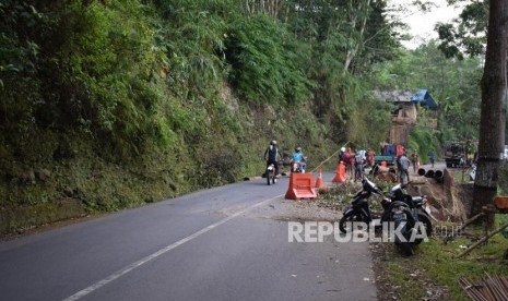 Sejumlah pekerja dari Dinas Bina Marga dan Penataan Ruang membenahi pinggiran jalan yang longsor di ruas jalan provinsi batas kabupaten Garut dan Tasikmalaya, di Kecamatan Singaparna, Kabupaten Tasikmalaya, Senin (28/5).